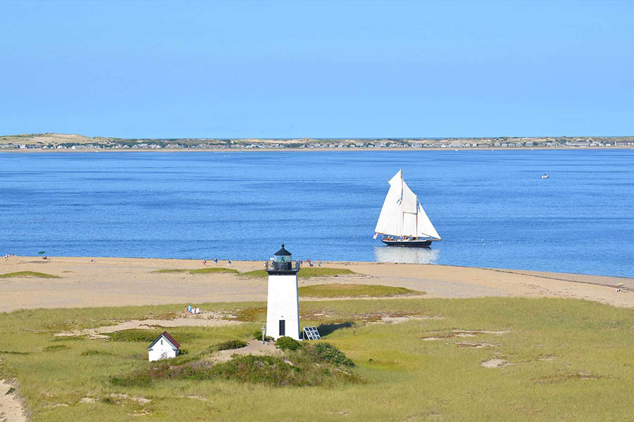 Sailboat passing a lighthouse